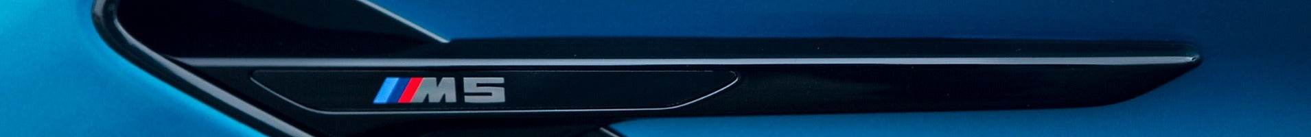 Black gloss fender side gill with ///M5 badge on a matte blue BMW F90 M5 — IND Distribution