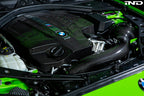 Black carbon engine cover for BMW F87 M2 N55 by Eventuri, exterior view showing sleek, high-performance design.