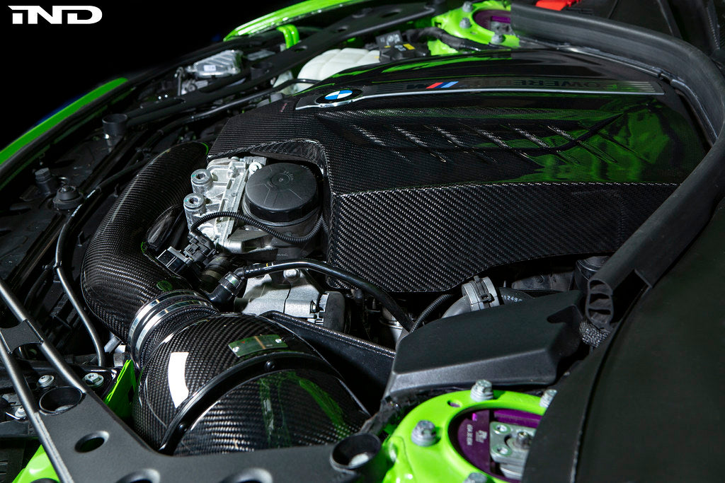 Black carbon engine cover for BMW F87 M2 N55 by Eventuri, exterior view showing sleek design and branding details.