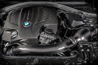 Eventuri black carbon engine cover for BMW F-Chassis N55 performance engine, showcasing sleek, lightweight design and branding details.