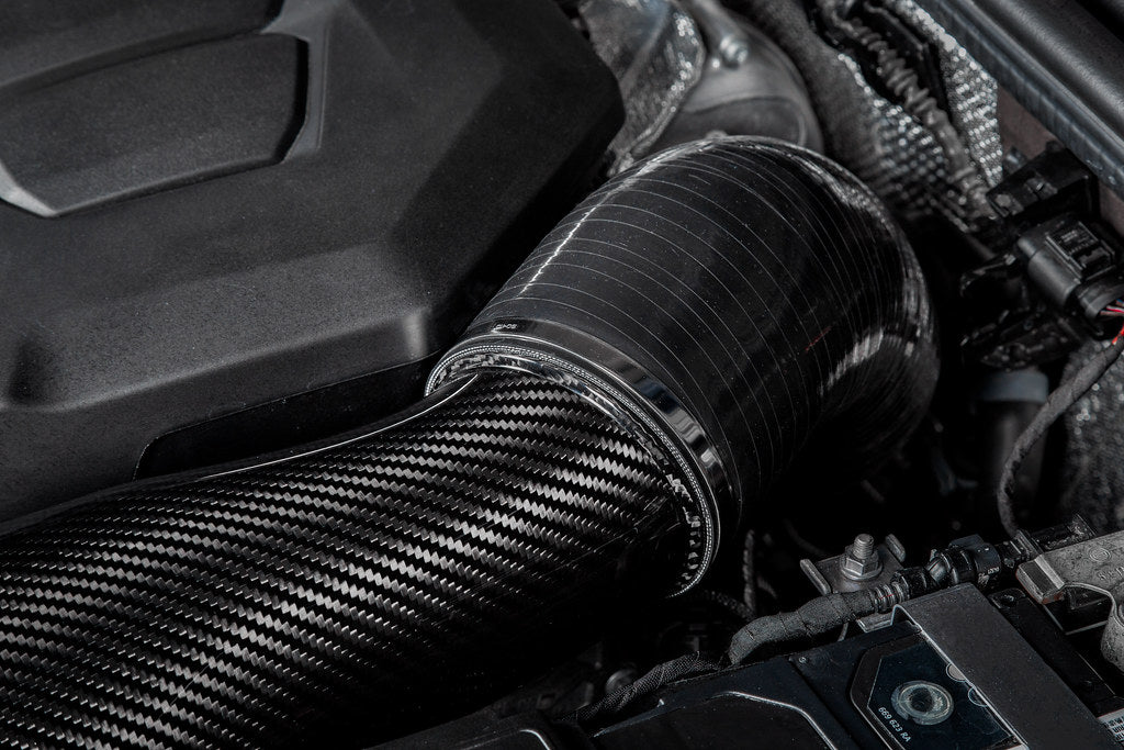 Close-up of a car engine with a carbon fiber air intake system.