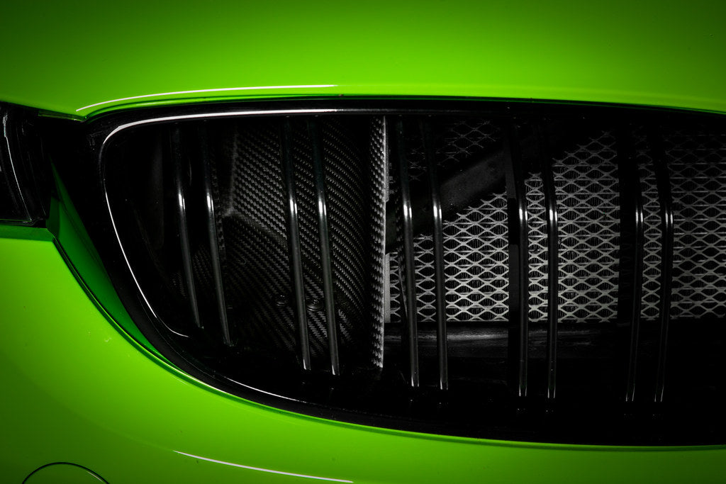 Eventuri black carbon air scoop set for BMW F8X M3 and M4 performance car, showcasing sleek aerodynamic design.