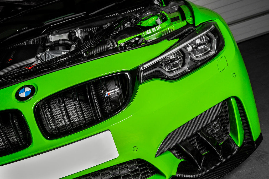 Eventuri BMW F8X M3 M4 black carbon air scoop set for performance enhancement, shown installed on vehicle engine bay