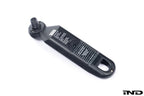 BMW electronic tire pressure gauge in use, showing digital display and compact design for accurate tire pressure measurement.
