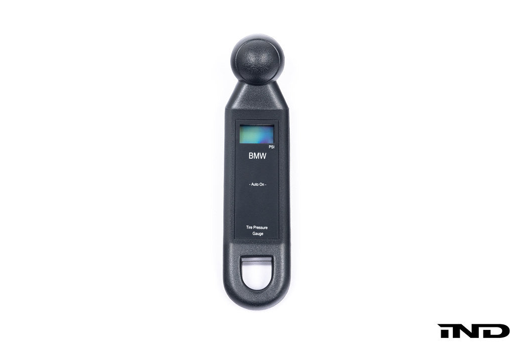 BMW electronic tire pressure gauge in a lifestyle setting, showing digital display and compact design for easy tire pressure checks.