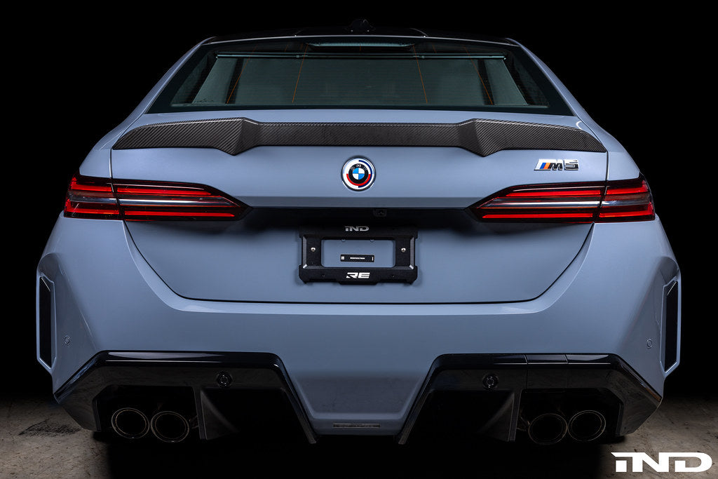 Alpha N G90 M5 carbon rear trunk spoiler on exterior of vehicle, showcasing sleek aerodynamic design and matte black finish.