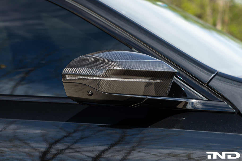 TREVORA G90 M5 G60 i5 M60 carbon exterior mirror cover set on a vehicle, showcasing sleek black carbon finish.
