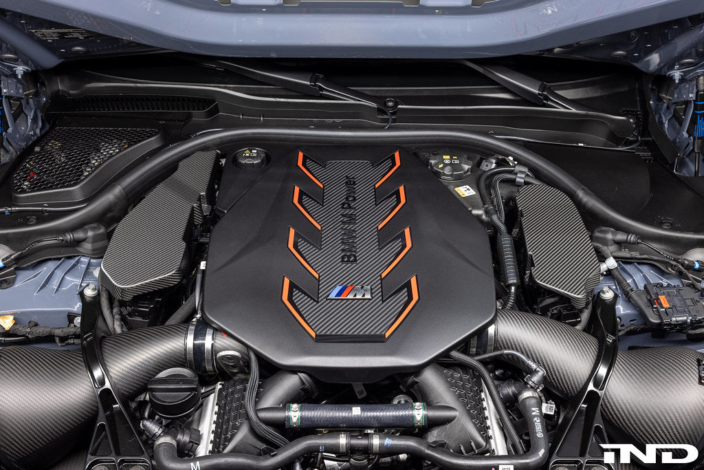 AutoTecknic G90 G99 M5 carbon engine cover extension set installed on car's exterior, showcasing sleek black carbon fiber finish.