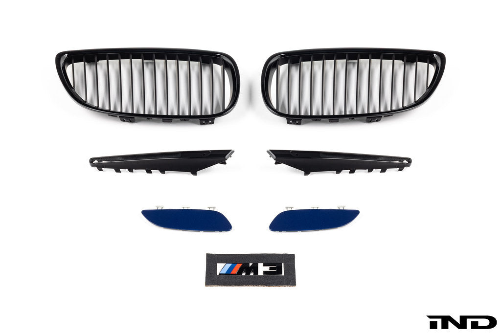 IND E9X M3 exterior cosmetic package showing carbon fiber accents and sleek aerodynamic enhancements on a black car.