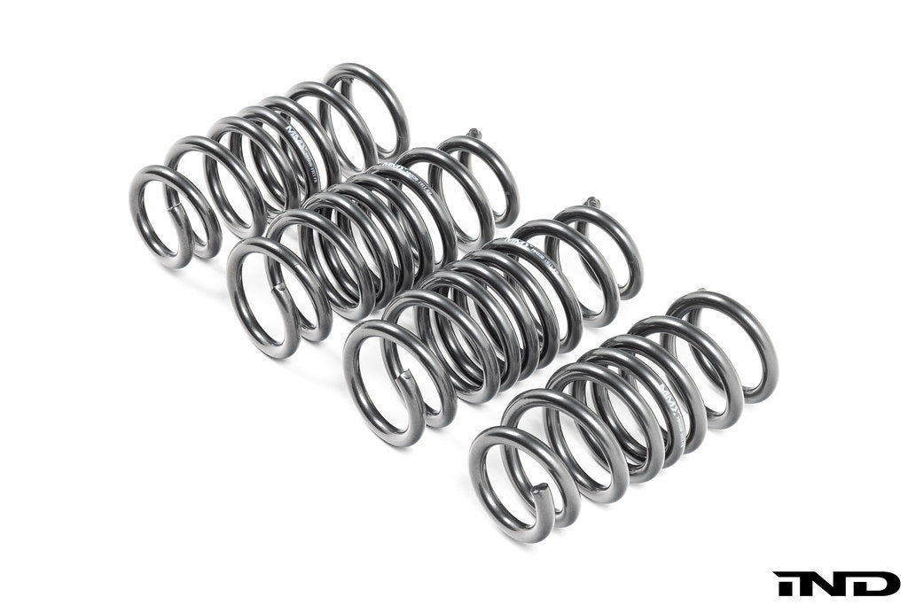MMX Performance G90 G99 M5 xDrive suspension lowering spring set installed on a vehicle, showcasing the black springs for improved ride.