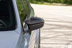 TREVORA G90 M5 / G60 i5 M60 carbon exterior mirror cover set on a vehicle, showcasing sleek black finish and aerodynamic design.