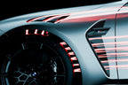 Close-up of a car's wheel and side profile with dynamic light effects on a dark background
