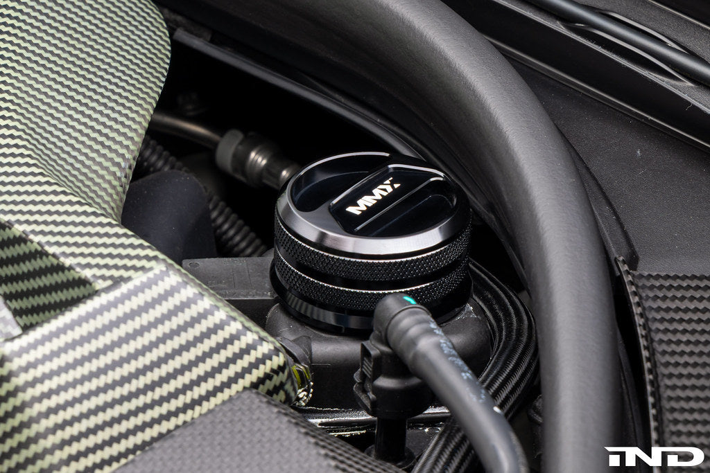 MMX Performance BMW billet coolant expansion cap, durable metal engine component with performance branding, close-up detail.