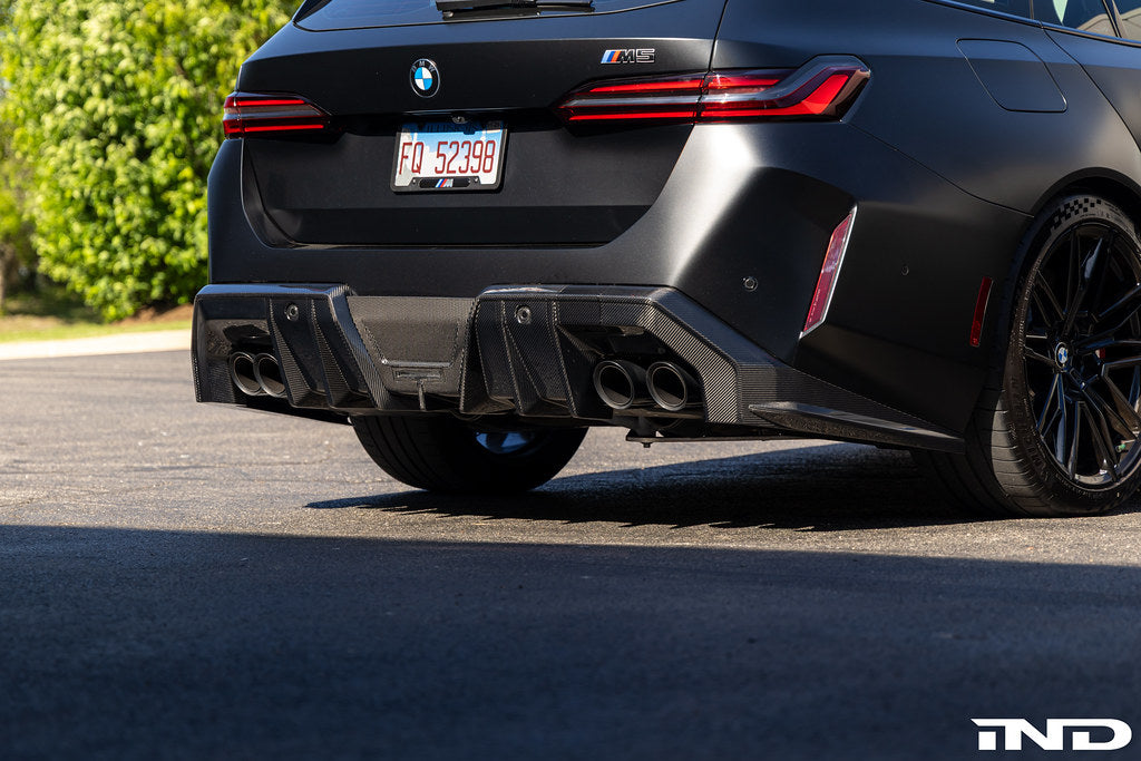 TREVORA G90 G99 M5 carbon fiber rear diffuser installed on exterior of vehicle, showcasing aerodynamic design and textured finish.