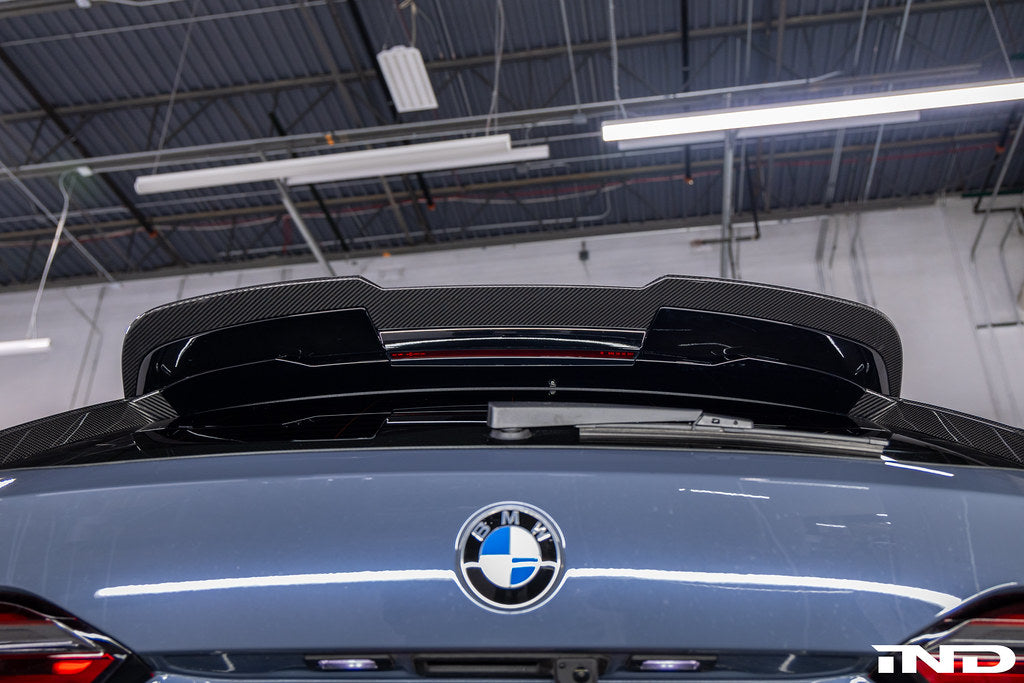 TREVORA G99 M5 carbon fiber rear roof spoiler mounted on car exterior, showcasing aerodynamic design and sleek finish.