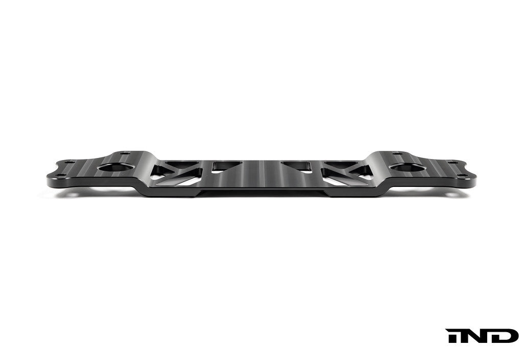 MMX Performance BMW G87 M2 Underbody Chassis Brace on a white background, precision CNC machined from billet 6061-T6 aluminum to provide additional exhaust clearance, increased chassis rigidity, and direct OEM-fit installation.