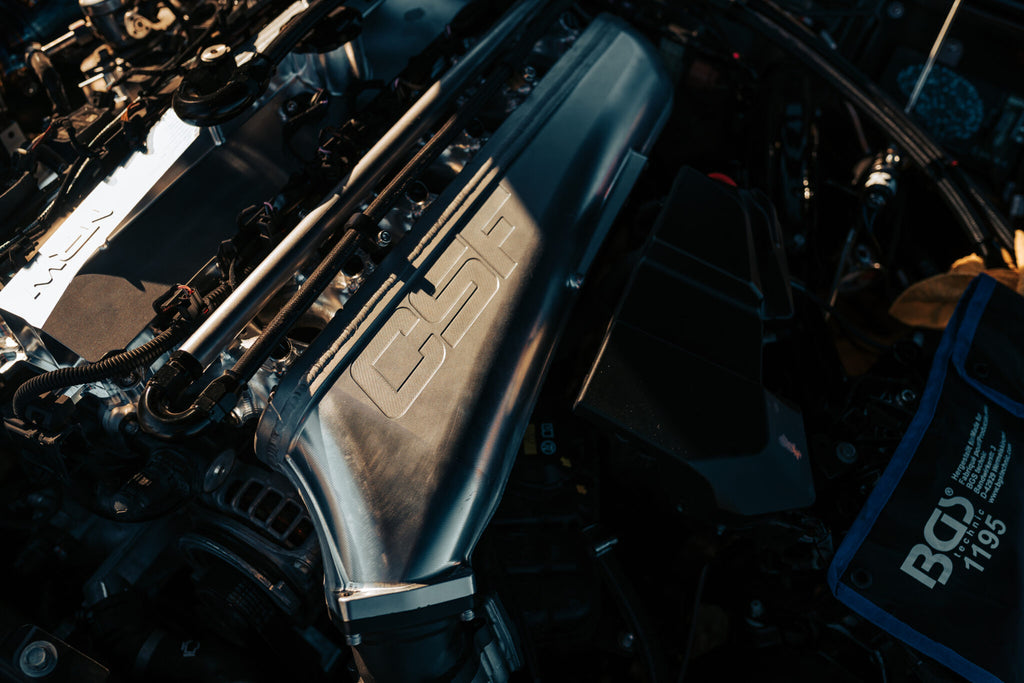 CSF B58 billet air-to-air competition manifold installed on a vehicle, showcasing its performance cooling component and sleek metal design.