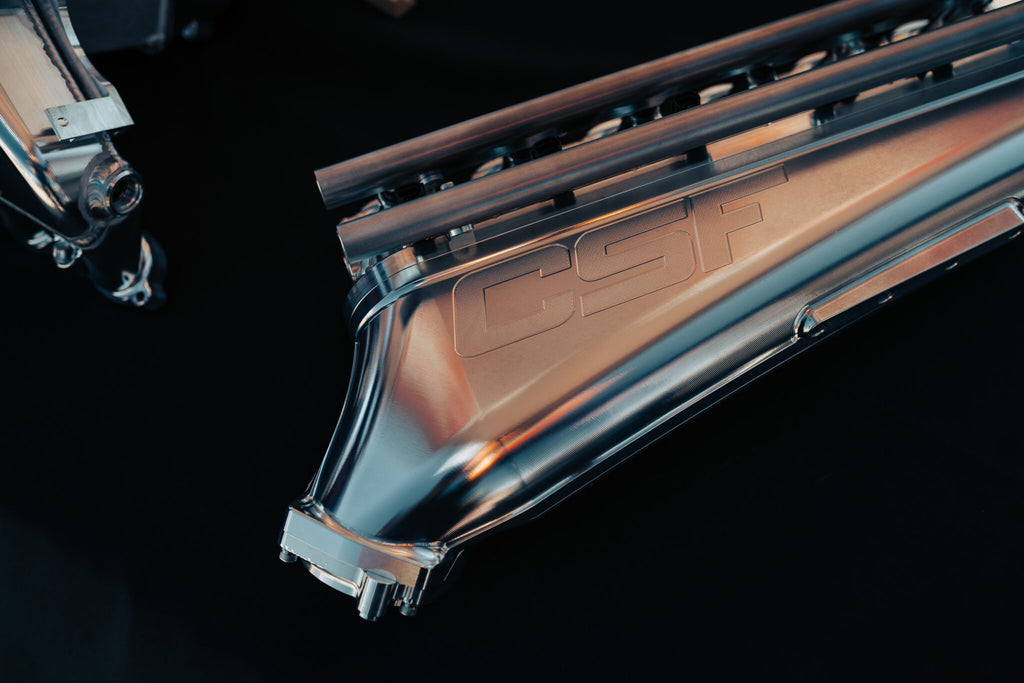 CSF B58 Billet Air-to-Air Competition Manifold for performance cooling, shown off the car with polished metal finish.