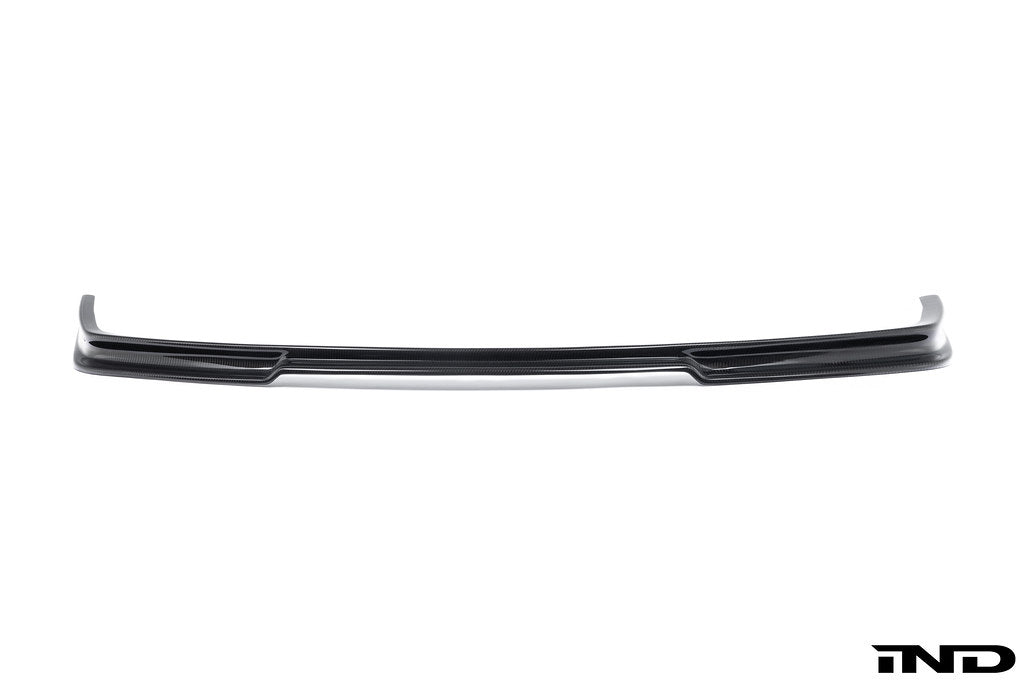 Alpha-N E36 M3 Carbon GT front lip installed on a white background, showcasing its sleek exterior design and lightweight carbon material.