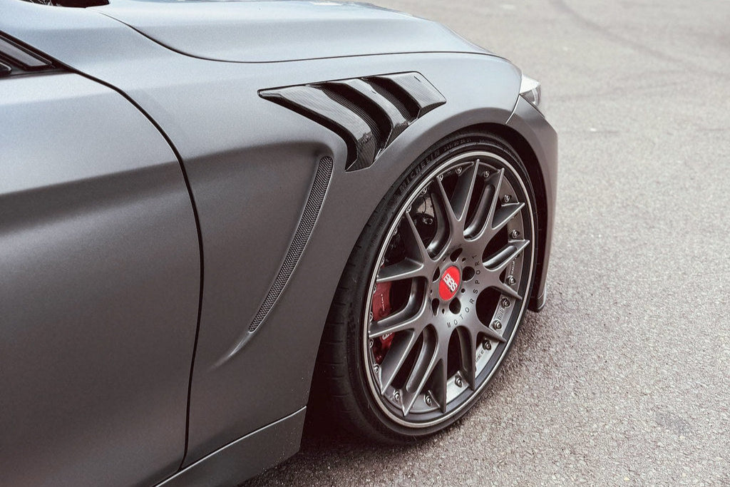 Alpha N F82 M4 carbon vented front fender set installed on a vehicle, showcasing sleek, lightweight exterior car modification.