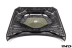Alpha N F87 M2 Carbon Corse vented hood shown on white background, highlighting its lightweight carbon fiber design and vented styling.