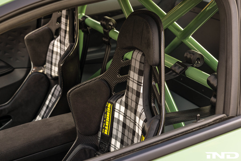 Interior view of the Alpha N G87 M2 bolt-in harness bar installed in a vehicle, showcasing its sturdy metal construction and mounting points.