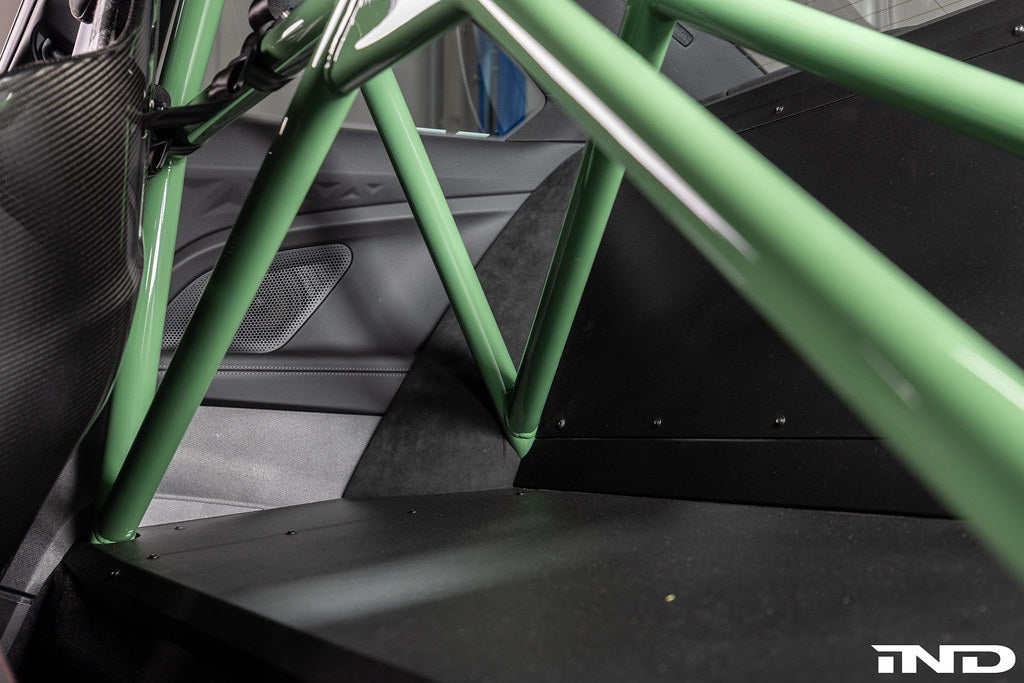Alpha N G87 M2 bolt-in harness bar installed inside car interior, providing secure attachment points for racing harnesses.