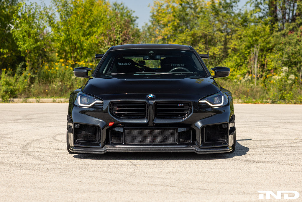 Alpha N G87 M2 carbon adjustable front lip installed on vehicle, showcasing its sleek exterior design and Class 3 style.
