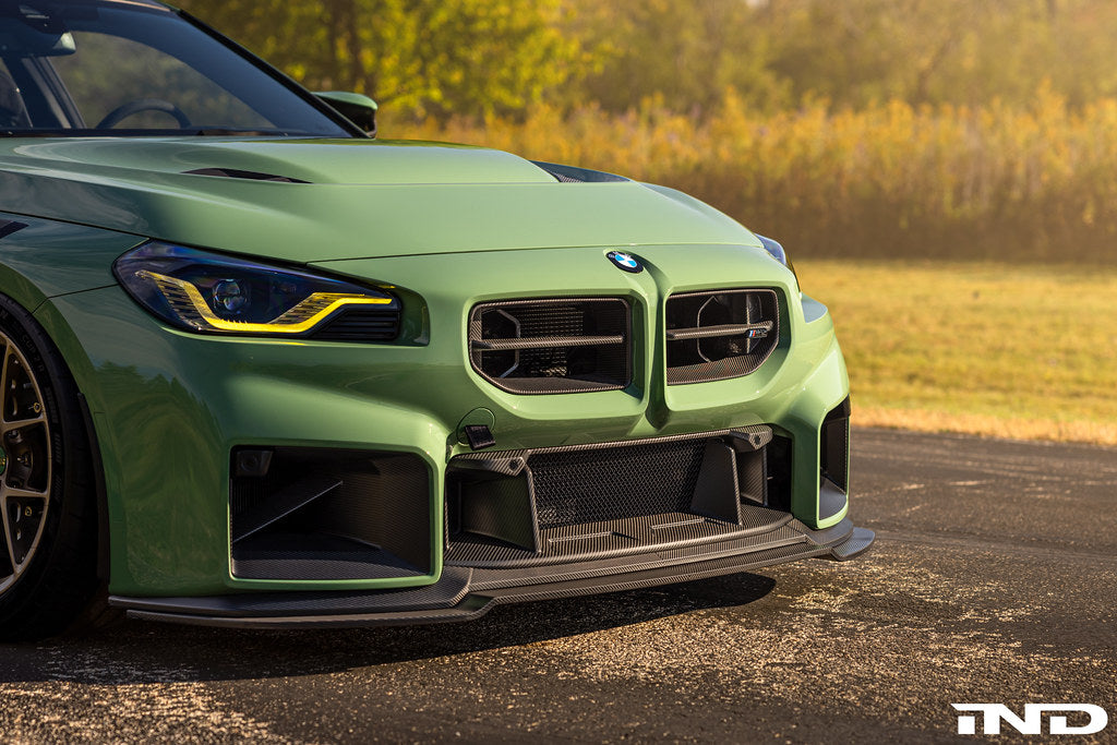 Alpha-N G87 M2 carbon adjustable front lip installed on a vehicle, showcasing its sleek, aerodynamic exterior design.