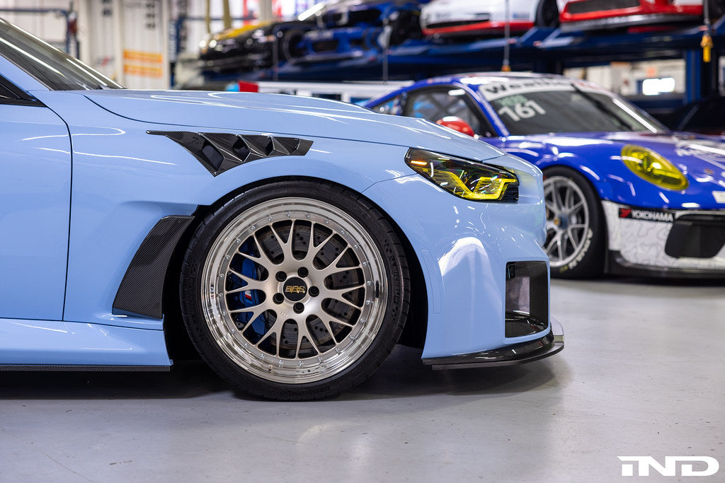 Alpha N G87 M2 carbon adjustable front lip installed on a vehicle exterior, showcasing its sleek design and Class 3 style.
