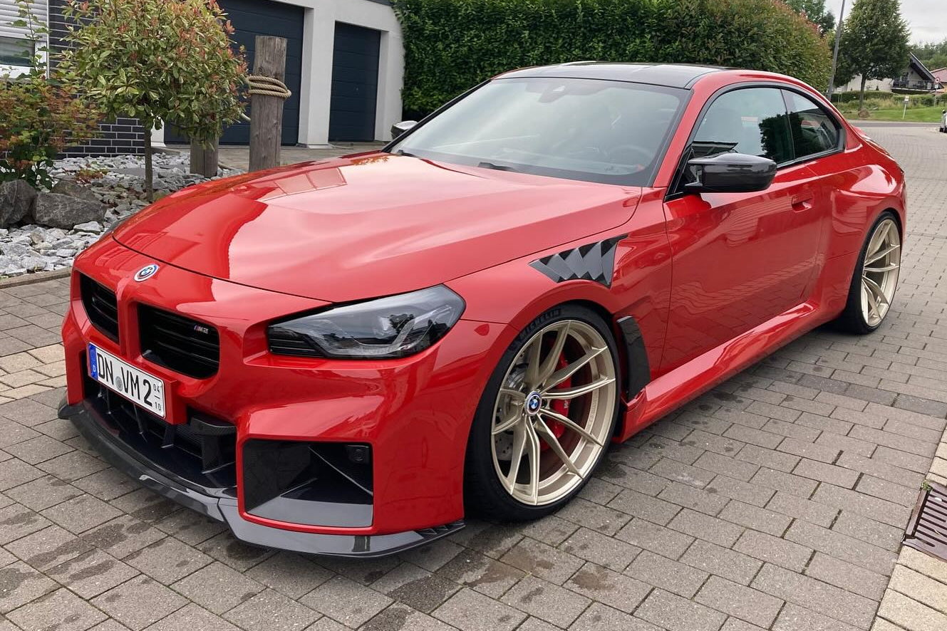 Alpha N G87 M2 Carbon Clubsport front lip installed on vehicle, showcasing sleek aerodynamic exterior enhancement.