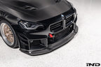 Alpha-N Carbon Corse front splitter installed on a Black Sapphire BMW G87 M2, enhancing the front-end appearance with pre-preg carbon fiber construction and aggressive styling.