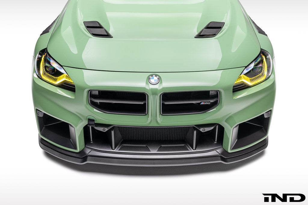 Alpha N G87 M2 carbon front center bumper trim installed on a vehicle's exterior, showcasing sleek, lightweight carbon fiber design.
