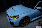 Alpha N G87 M2 carbon vented hood with front vent insert installed on a vehicle, showcasing its sleek exterior design.