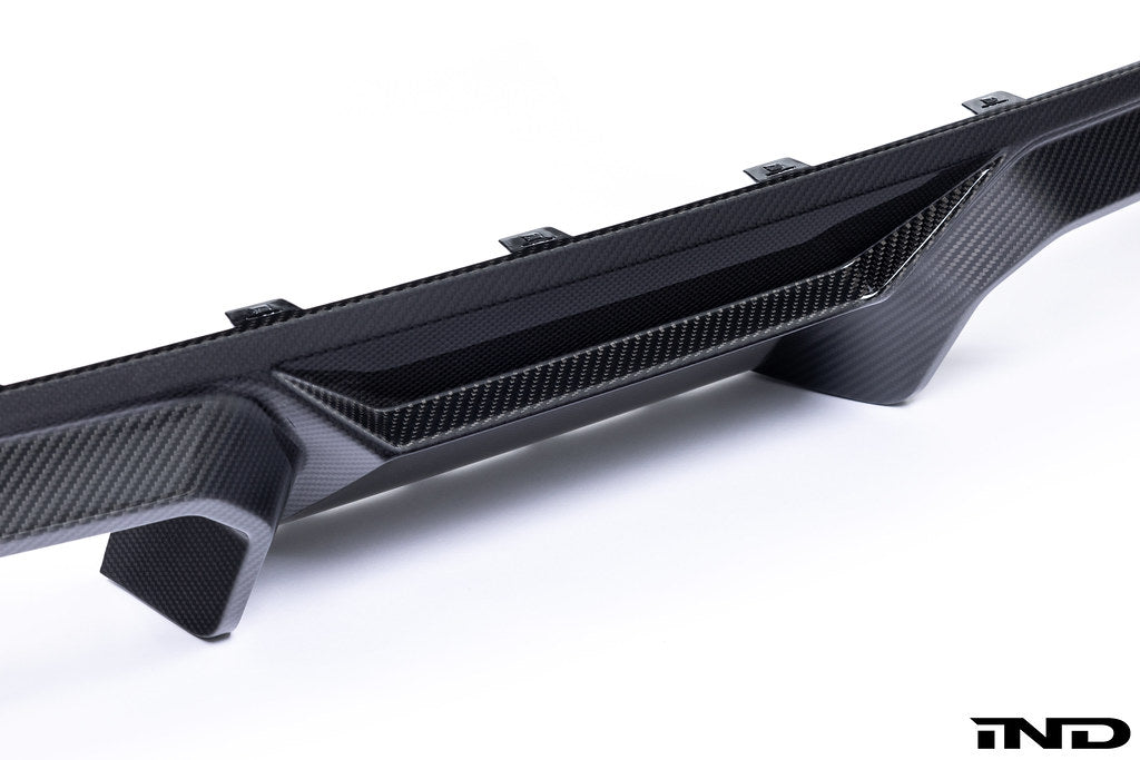 Alpha N G87 M2 carbon rear diffuser installed on car, showcasing sleek exterior design on a white background.