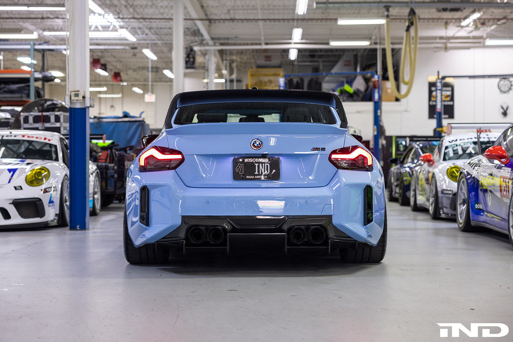 Alpha N G87 M2 carbon rear underbody floor kit installed on vehicle, showcasing lightweight aerodynamic exterior enhancement.