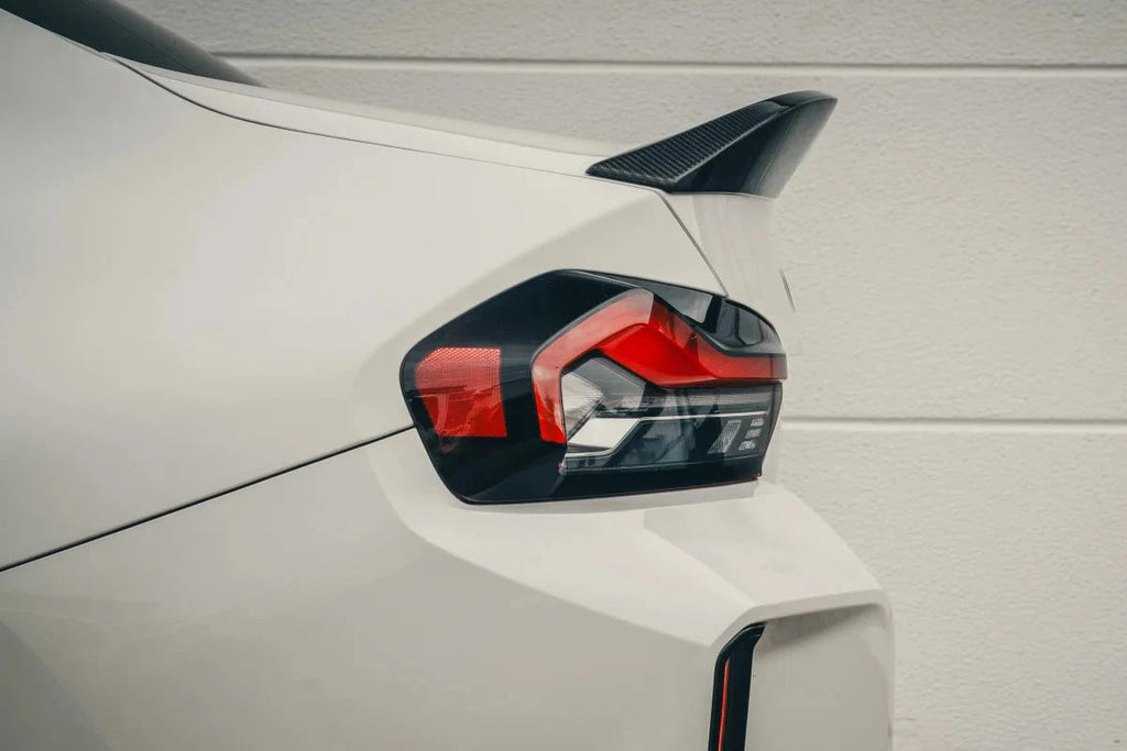 Alpha N G87 M2 carbon trunk spoiler installed on exterior of BMW M2, enhancing sporty look with lightweight carbon fiber design.