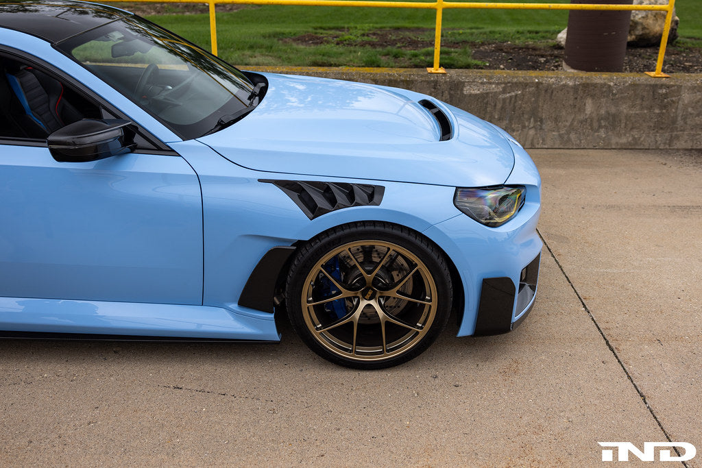 Alpha N G87 M2 carbon vented hood installed on a car, showing its sleek, lightweight design and vented exterior for improved airflow.