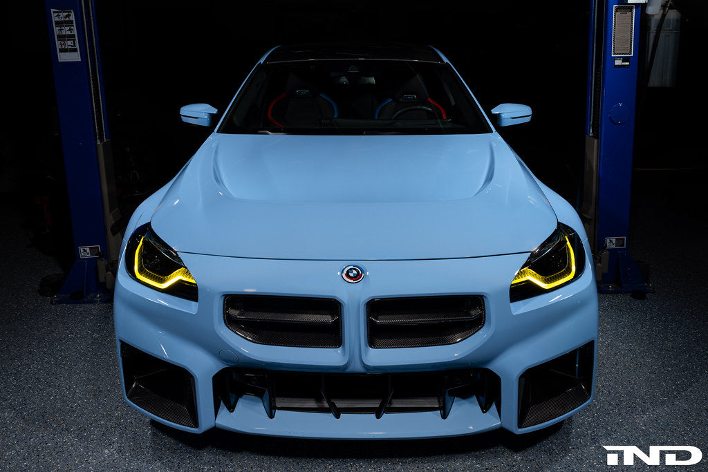 Alpha N G87 M2 carbon vented hood installed on a car, showcasing lightweight exterior design and venting features.