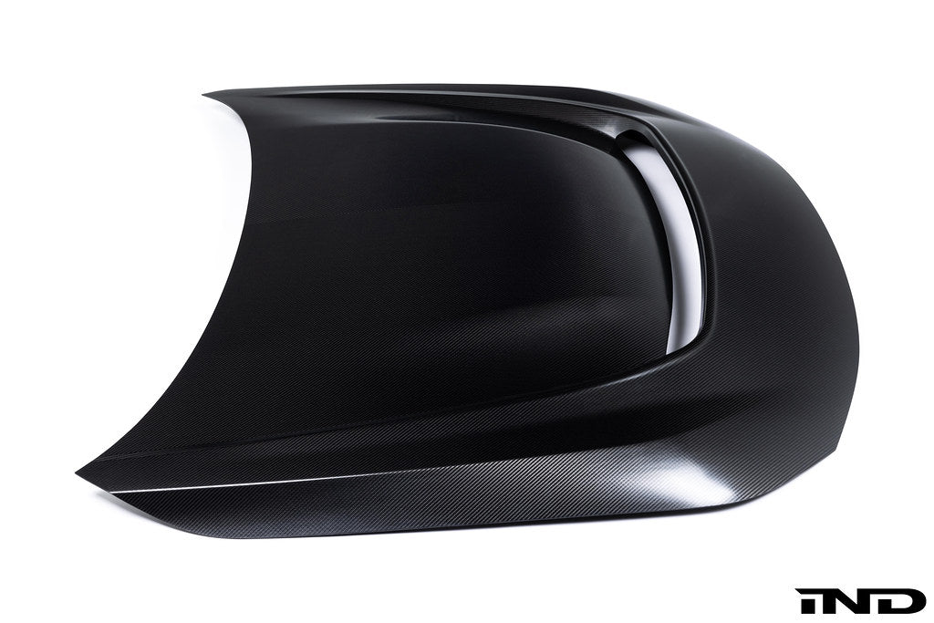 Alpha-N G87 M2 carbon vented hood on a white background, showcasing its sleek exterior design and lightweight construction.