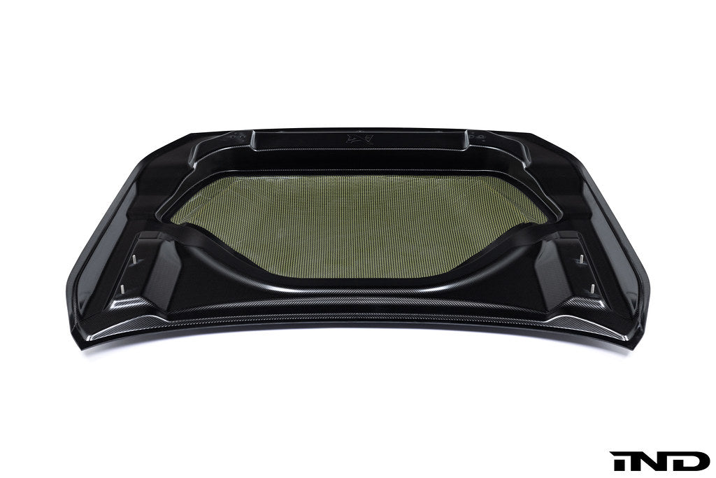 White Alpha N G87 M2 carbon vented hood shown on a white background, highlighting its lightweight, vented exterior design.