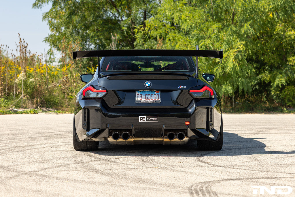 Alpha N G87 M2 GT3 Swan Neck rear wing installed on the exterior of a car, showcasing its aerodynamic design and mounting details.