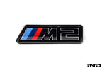 Alpha N G87 M2 LCI front grille emblem retainer with OEM M2 badge on white background, for BMW exterior customization.