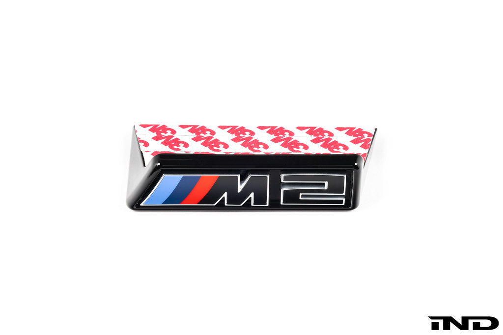 Alpha-N G87 M2 LCI front grille emblem retainer with BMW OEM M2 badge on white background.