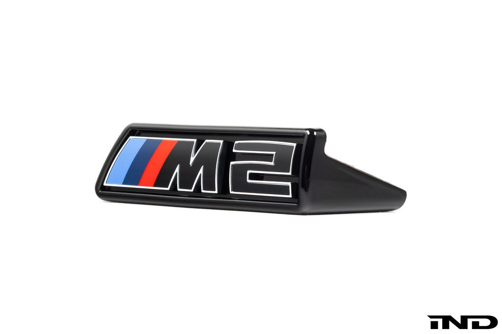 Alpha-N G87 M2 LCI front grille emblem retainer with BMW OEM M2 badge on white background.