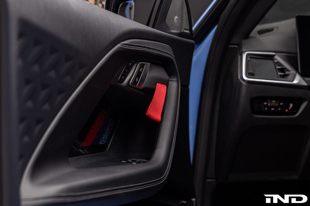 Alpha N G87 M2 Motorsport interior door pull kit installed, featuring sleek design and durable materials for enhanced grip.