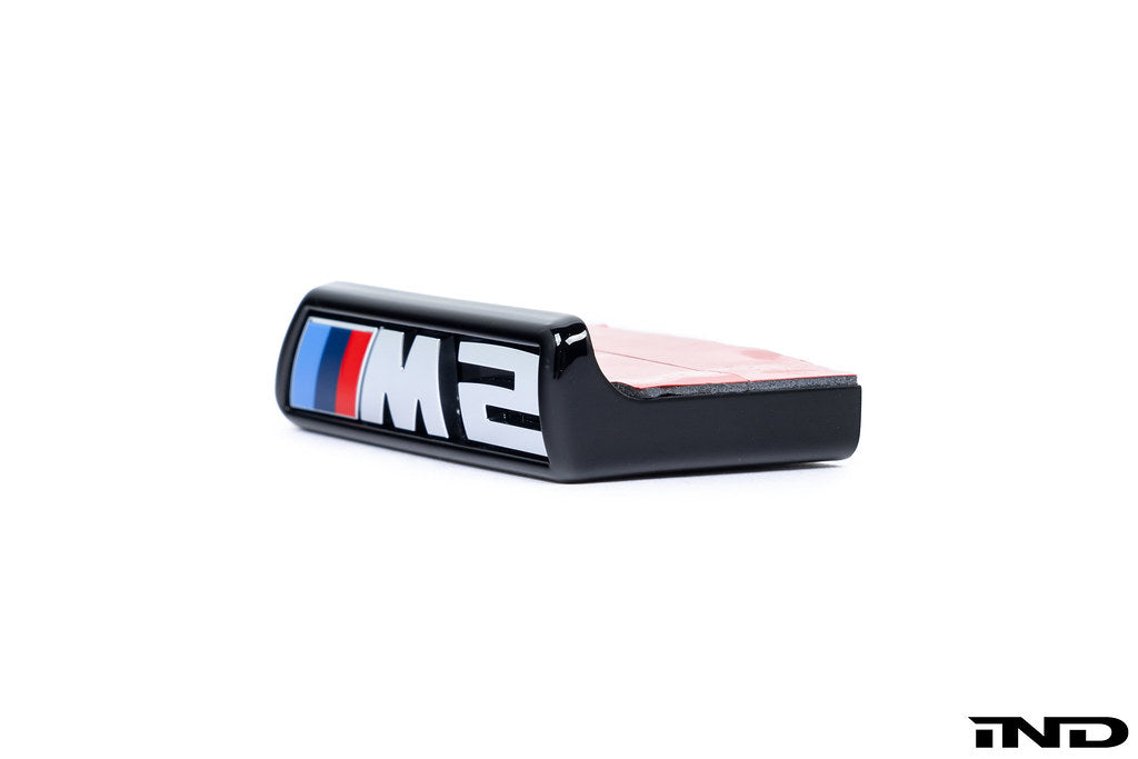 Alpha N G87 M2 front grille emblem retainer for Pre-LCI BMW, shown on a white background. Exterior car accessory.