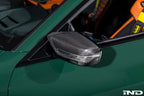 Alpha N G8X M2, M3, M4 carbon mirror cap set installed on exterior side of BMW vehicle, showcasing sleek black carbon finish.