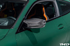 Alpha N G8X carbon mirror cap set installed on M2, M3, or M4 exterior mirrors, showcasing sleek black carbon fiber design.