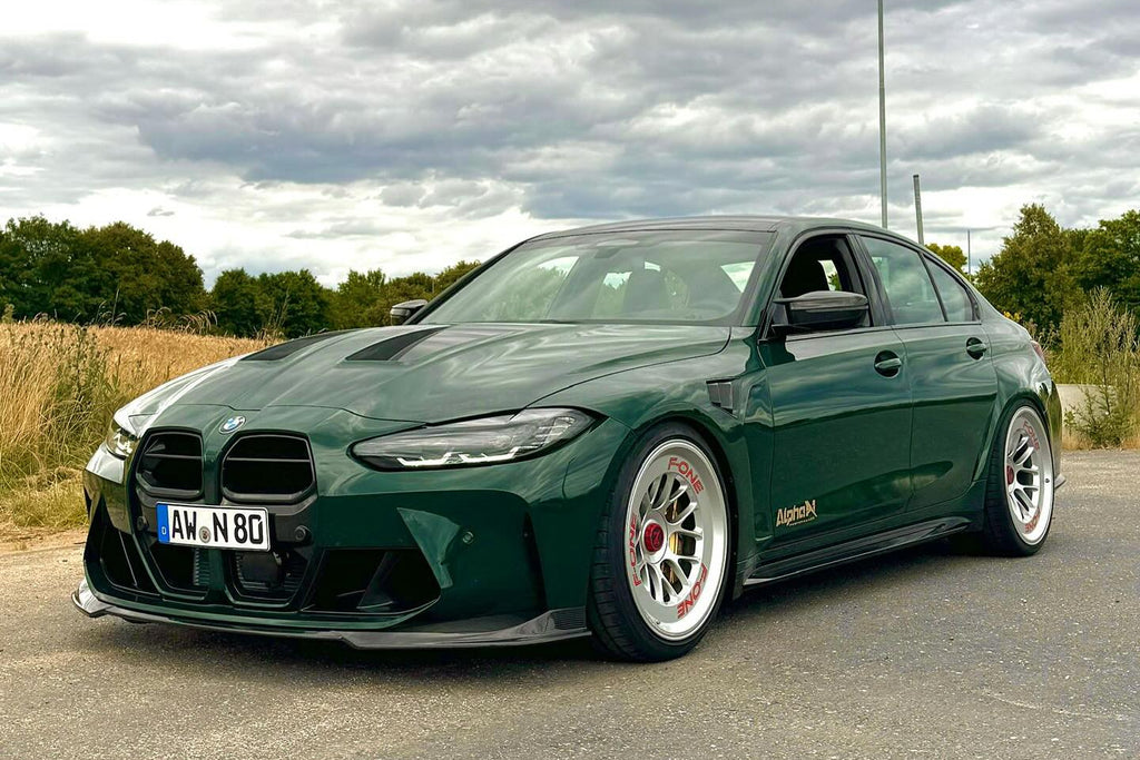 Alpha-N G8X M3 M4 carbon front spoiler installed on exterior of vehicle, showcasing sleek aerodynamic design.